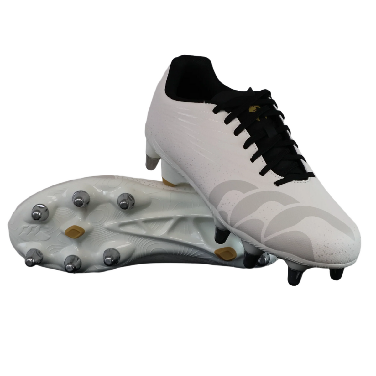 The Canterbury Stampede Groundbreak Team SG rugby boots in white feature black laces; one shoe displays the top view and the other reveals the studded sole, making them ideal soft ground boots for players seeking reliability.