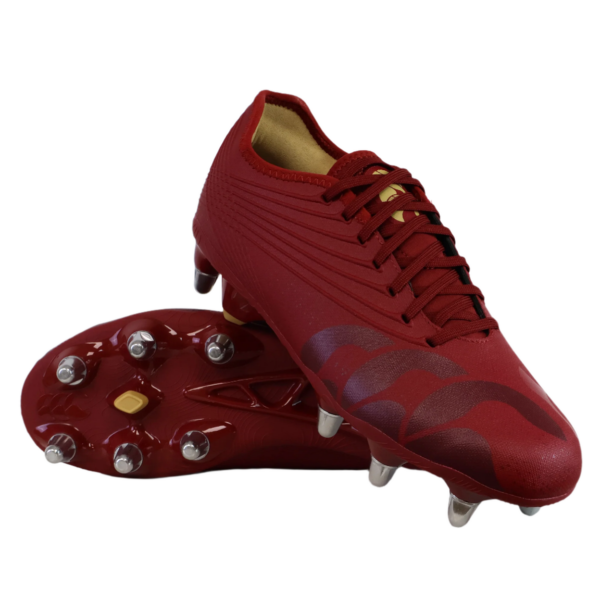 A pair of Canterbury Stampede Groundbreak Pro SG - Red Dahlia rugby boots by Canterbury, one upright and one on its side highlighting the metal studded sole—perfect soft ground boots for power and grip.
