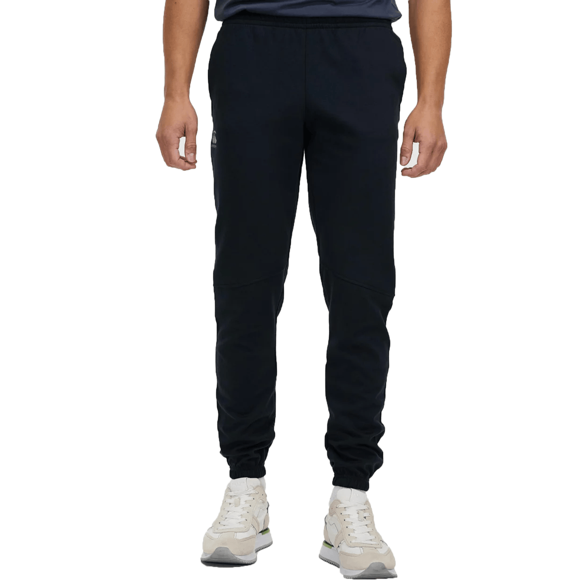 Man wearing Canterbury Tempo Vapodri Hybrid Cuffed Pant and light-colored sneakers, shown from the waist down.