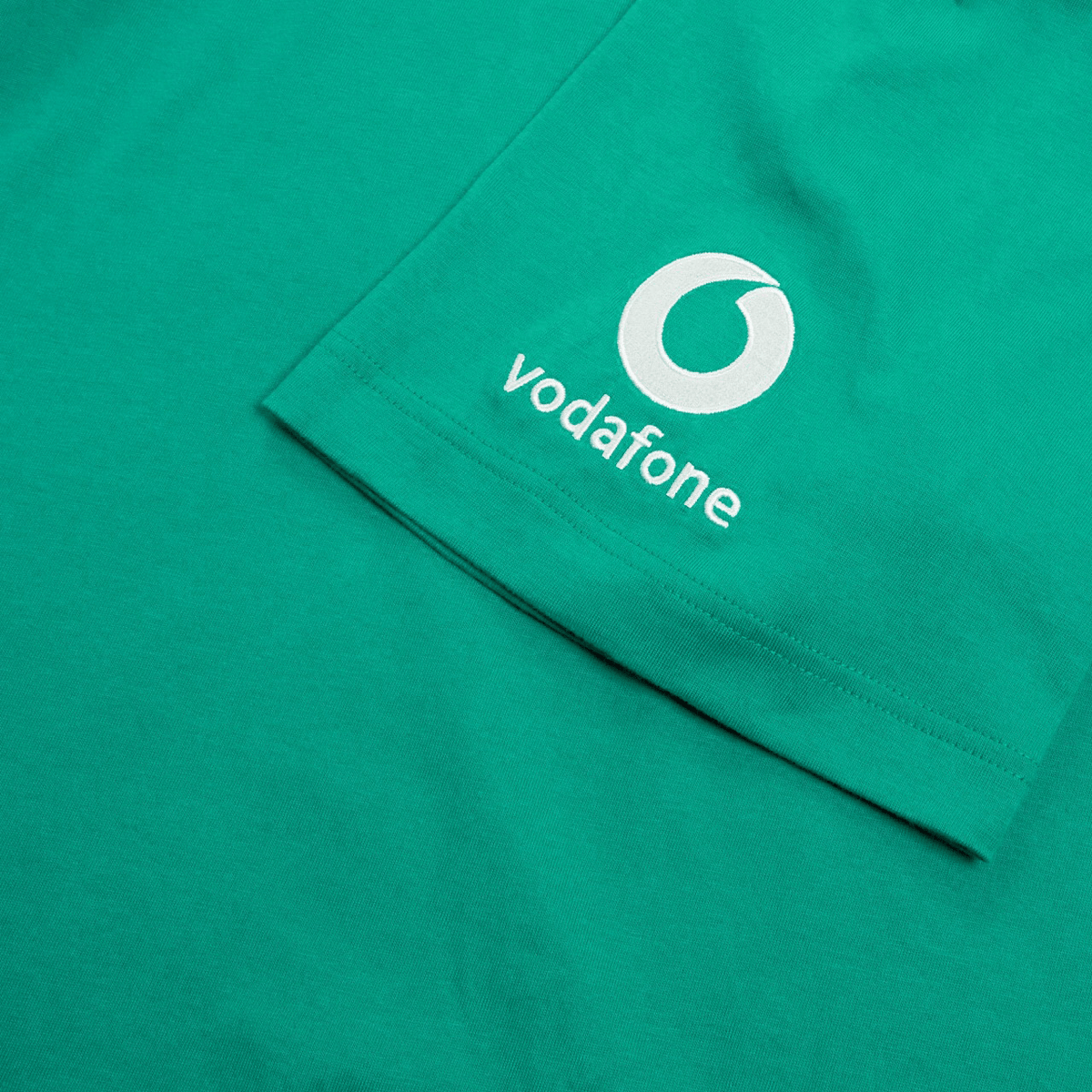 Canterbury&#39;s Ireland Team Cotton T-Shirt 24, in green, prominently displays a white &quot;vodafone&quot; logo and features the iconic Irish green emblem against a plain background.