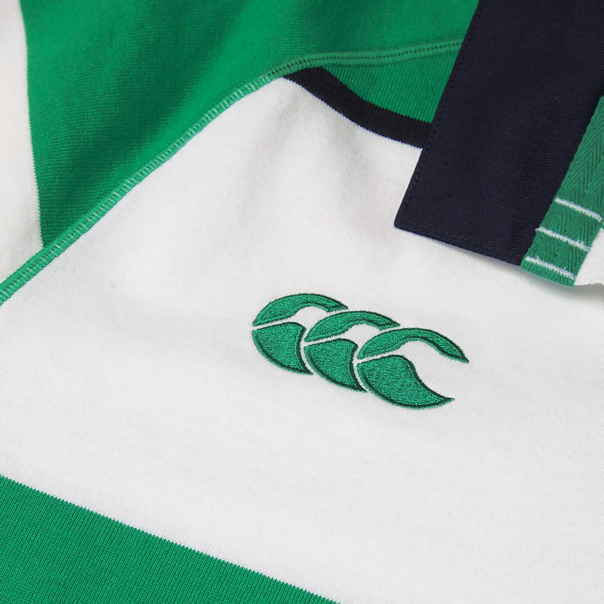 Close-up of the Ireland 25/26 Heritage Hooped Jersey by Canterbury, featuring green and white stripes and the iconic Canterbury logo—three overlapping C’s—in green, capturing its classic style.