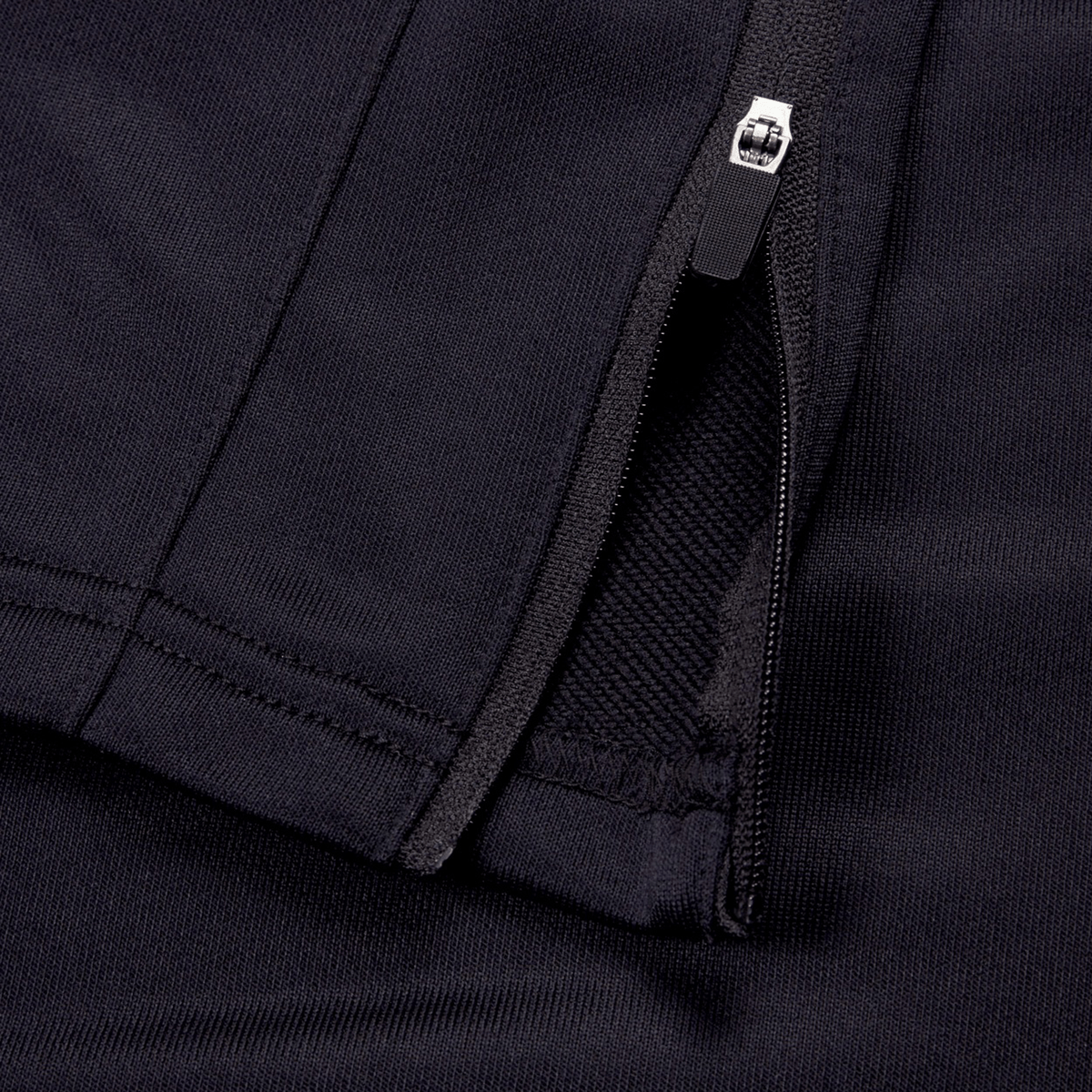 Close-up image of a black Ireland 24 Poly Knit Pant by Canterbury featuring a zipper partially unzipped, showcasing the texture and stitching details of the fabric, perfect for any Irish rugby fan.