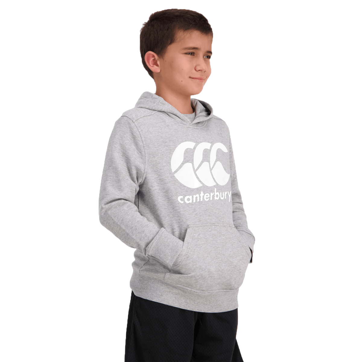 A child wearing a fleece-lined Canterbury Anchor Hoodie in grey and black shorts stands with hands in pockets, looking to the side.