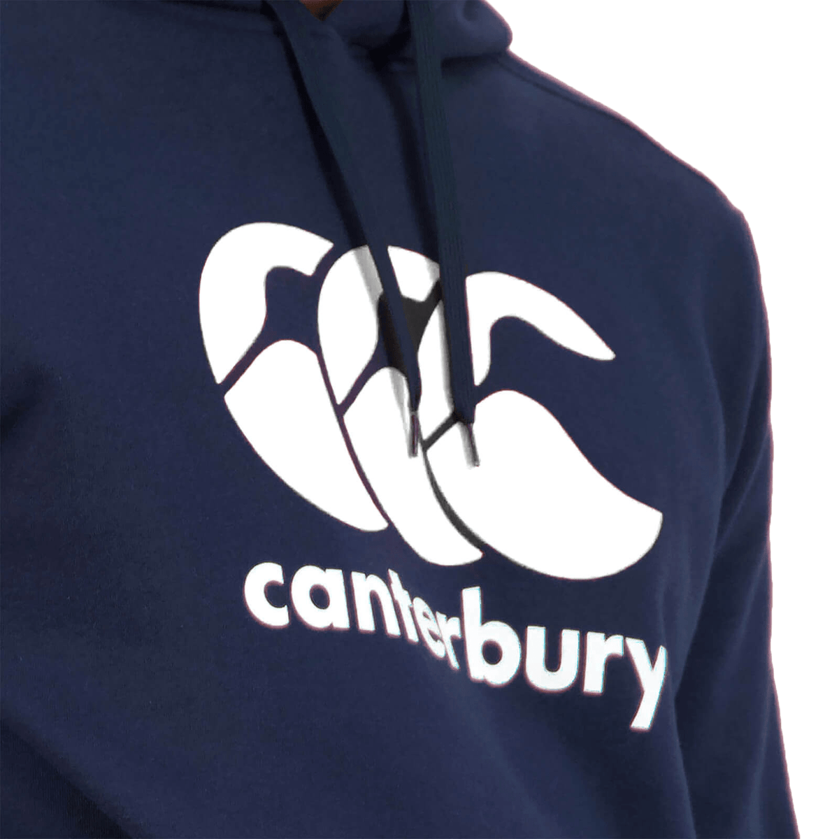 Close-up of a person wearing the Canterbury Anchor Hoodie in dark blue, featuring the word "Canterbury" and a stylized white overlapping wave logo on the front. This cozy, fleece-lined hoodie from Canterbury is perfect for staying warm while showing off your style.