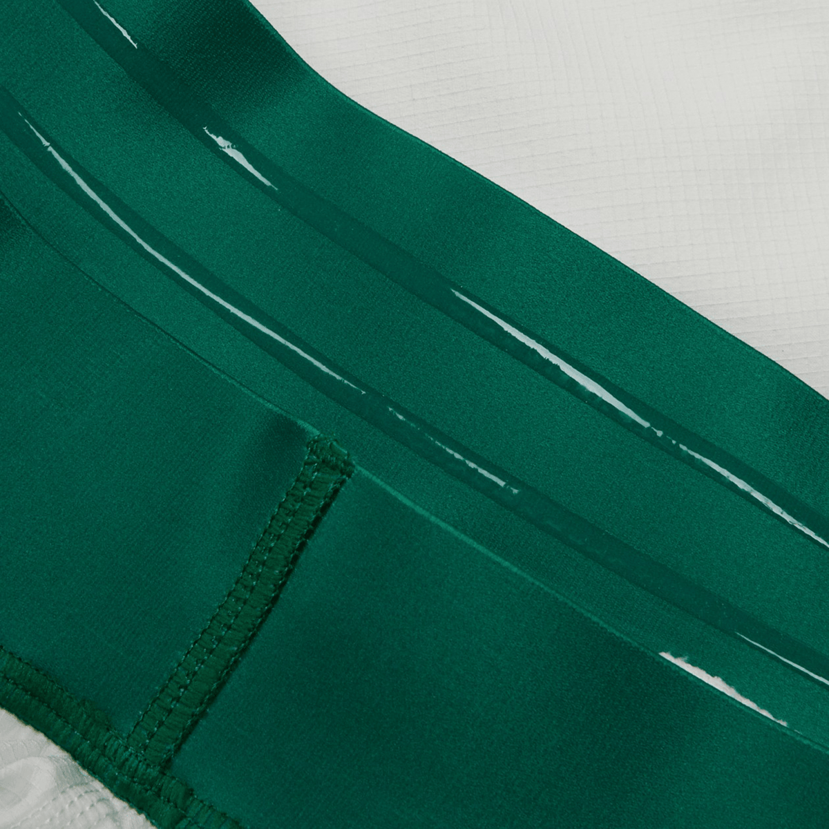 Close-up view of green and white fabric with visible stitching and seam detail, showcasing the durable design of the Ireland 24 Home Match Short by Canterbury.
