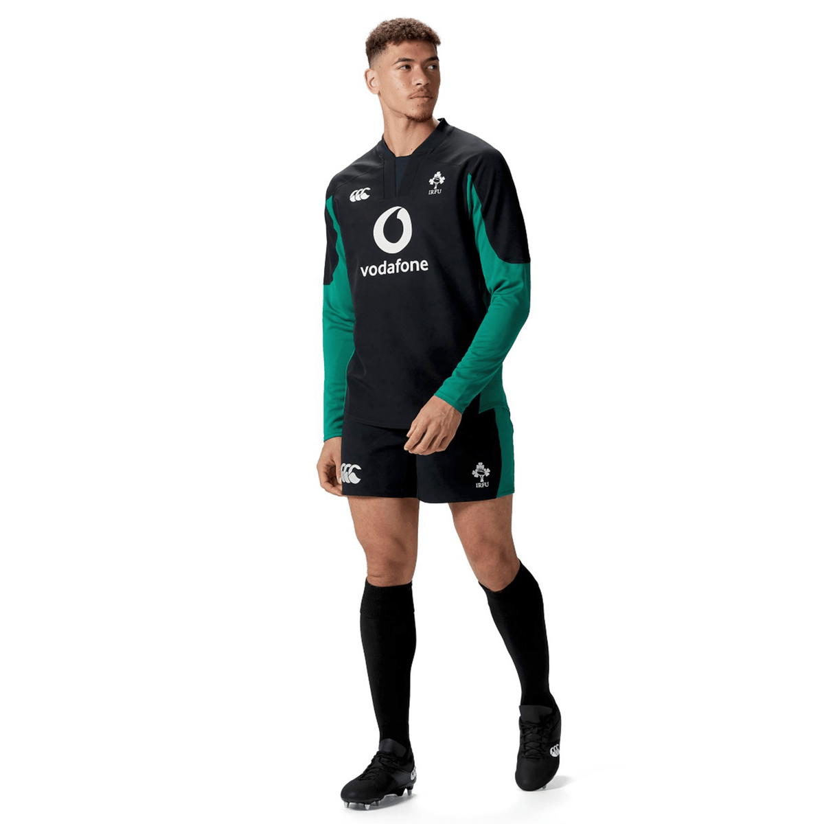A male athlete stands facing slightly left on a white background wearing the Canterbury Ireland 25/26 Tech Drill Top, which features black and green colors and the CCC logo.