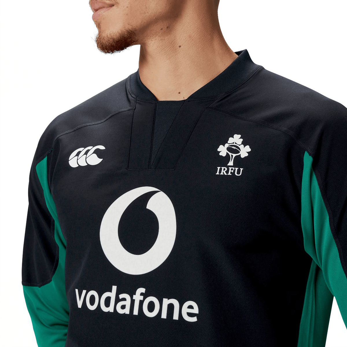 Someone is wearing the Ireland 25/26 Tech Drill Top by Canterbury, a black and green rugby top featuring the Canterbury and IRFU logos along with Vodafone branding.