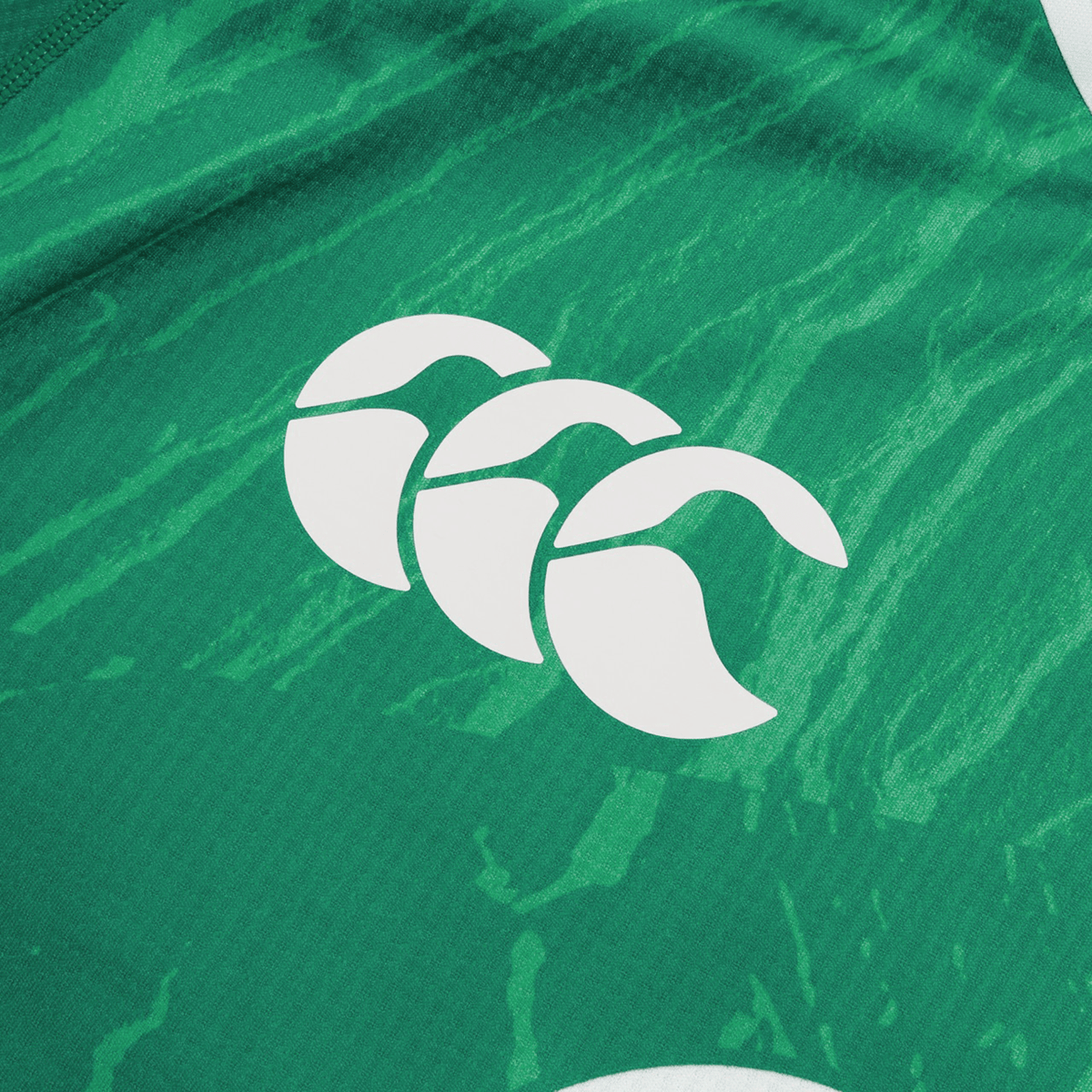 Close-up view of the Ireland 24 Home Pro Jersey by Canterbury&#39;s green fabric featuring a white triple wave logo.
