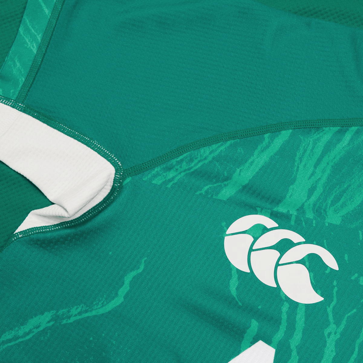 Detailed view of a Women&#39;s Ireland WIRFU Home Pro Jersey from Canterbury, featuring the official IRFU crest in white on stylized patterns. This green jersey, enhanced with VapoDri technology, combines style and performance.