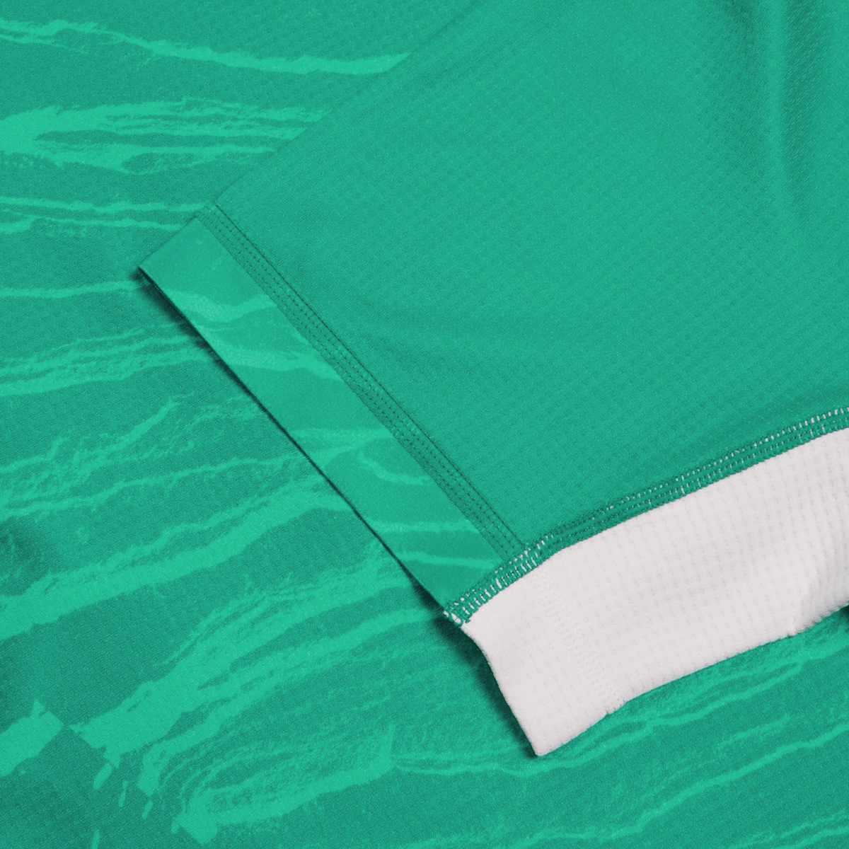 Close-up of textured wave-like patterns on the Women&#39;s Ireland 24 Home Pro Jersey by Canterbury, showcasing a green fabric with a white hem.