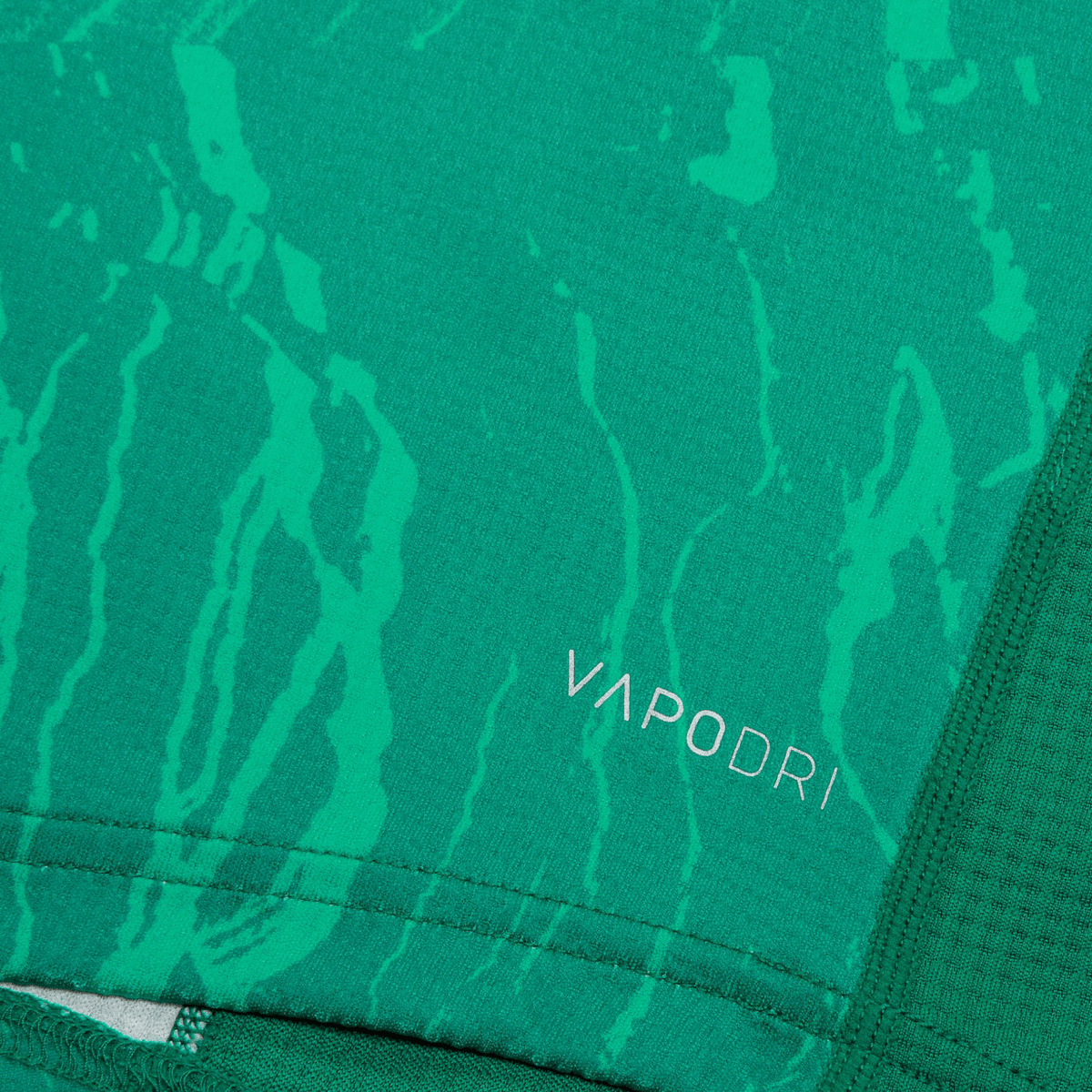 A close-up of a green fabric pattern shows &quot;Vapodri&quot; on the official Youth Ireland 24 Home Pro Jersey by Canterbury, featuring the iconic IRFU Crest.