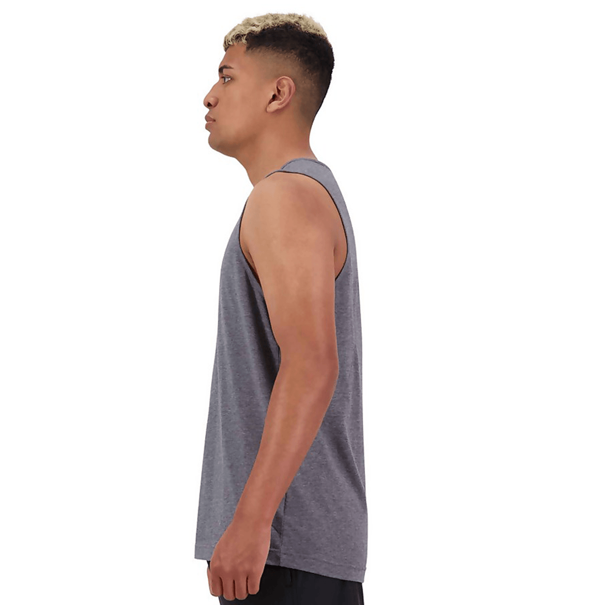 A man wearing a Canterbury Tempo Vapodri Singlet, made of recycled polyester, in a grey tank top and black shorts.