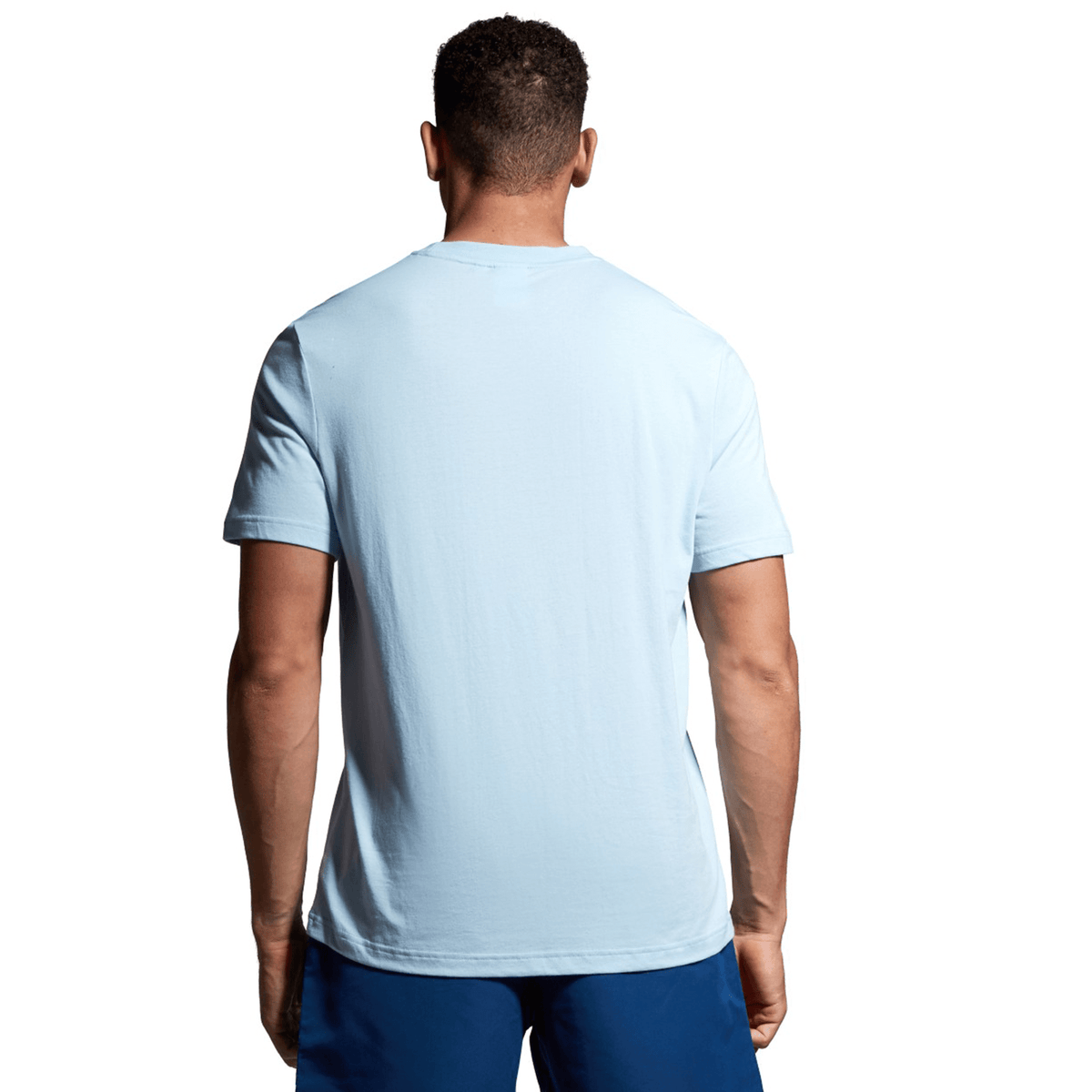 A man wearing a Canterbury Canterbury Uglies T-Shirt and dark blue shorts is standing with his back to the camera.