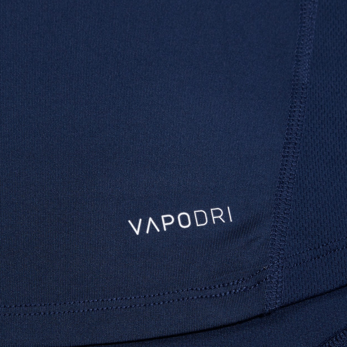 Close-up of the Canterbury Large Logo Superlight Tee fabric in navy, featuring white "VAPODRI" text and seam stitching, showcasing this lightweight performance shirt by Canterbury for rugby training.