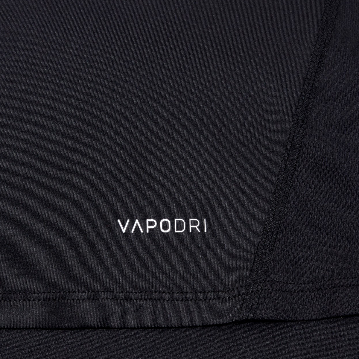 Close-up of a black Canterbury Large Logo Superlight Tee featuring "VAPODRI" in white text and visible seam stitching—a lightweight performance shirt from Canterbury, perfect for rugby training.