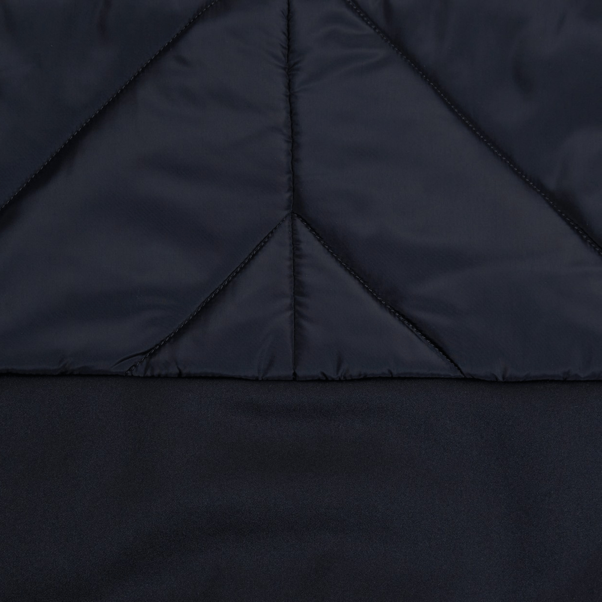 Close-up of a black quilted fabric showing detailed stitching and triangular pattern design, perfect for the Canterbury Elite Microlite Gilet.