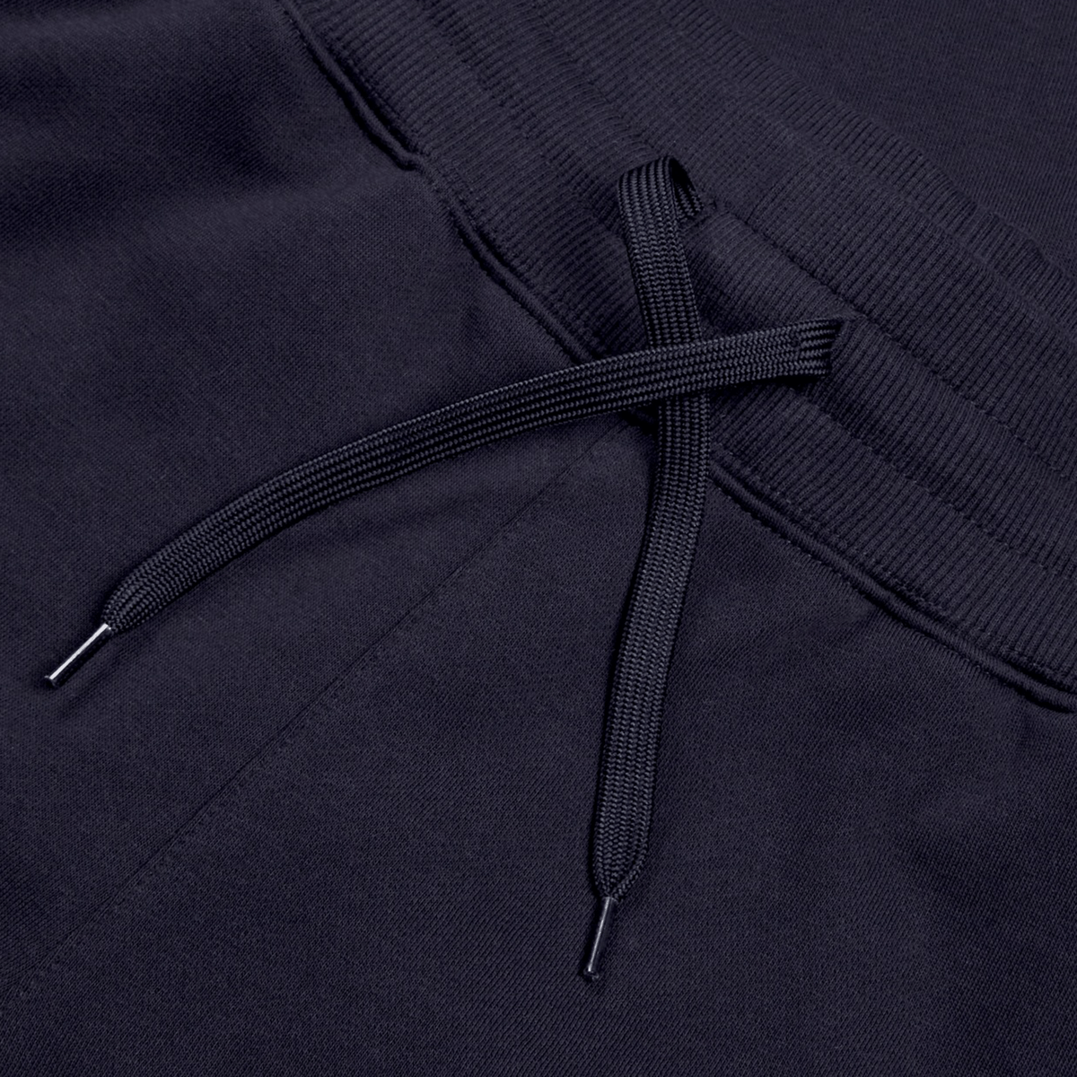 Close-up of the black drawstring on dark fabric, highlighting the textured material and stitching details of the cotton-blend fleece Women’s Leisure Sweatpant by Canterbury, complete with the Canterbury logo.