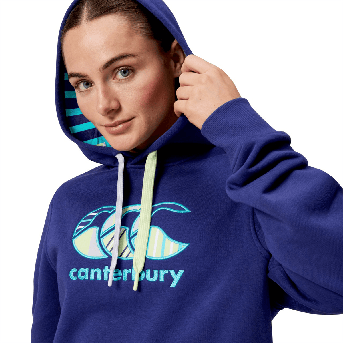 A person in a Canterbury Women&#39;s Uglies Hoodie, blue with the hood up, facing the camera.