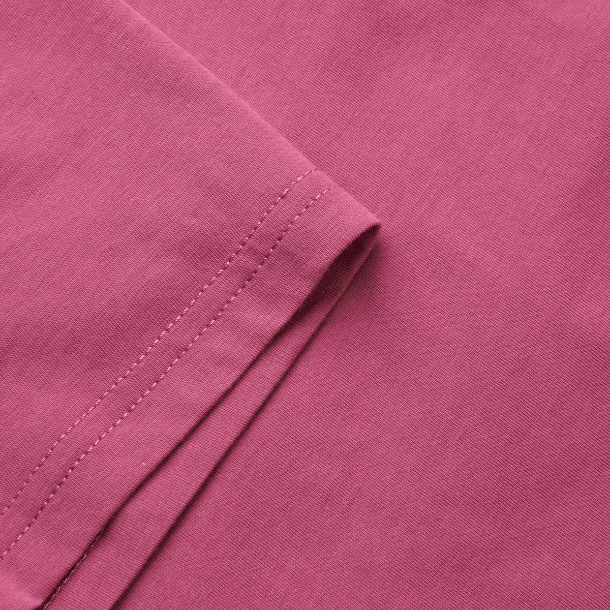 Close-up of elegantly folded Malaga Rose fabric, evoking the Women&#39;s Canterbury Uglies T-Shirt by Canterbury, with stitching visible along the edge.