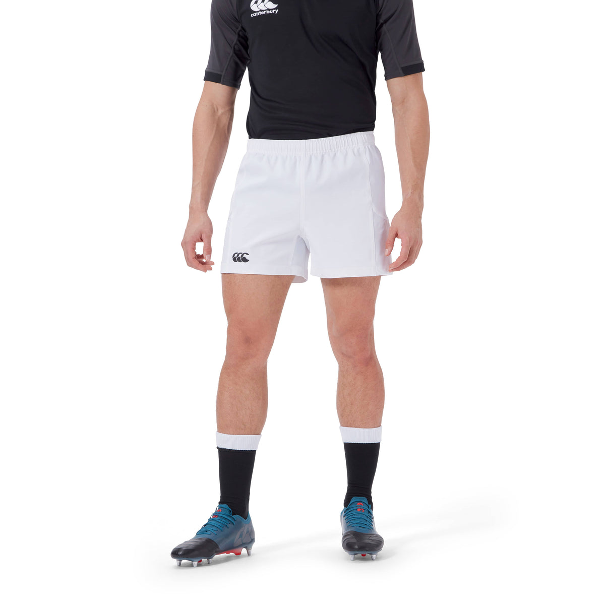 Person wearing a black and grey sports shirt made with recycled content, white Canterbury Advantage Short 2.0, black socks with white bands, and blue and black athletic shoes.