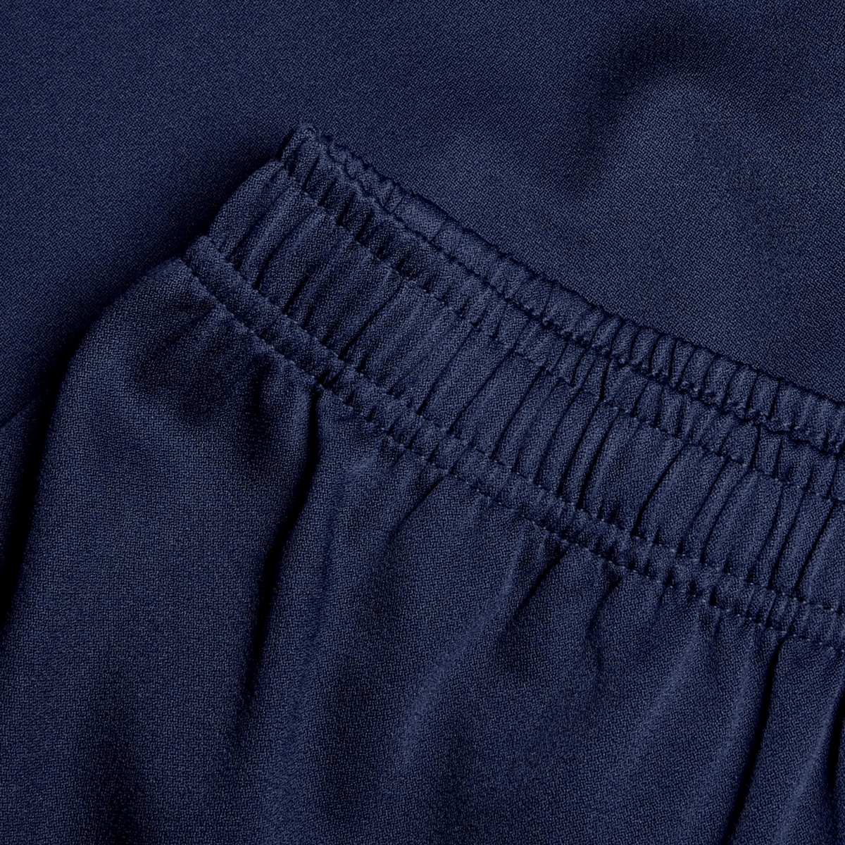 Close-up of navy blue fabric reveals an elastic waistband and gathered stitching, highlighting the durability of the Canterbury Professional Short 2.0.