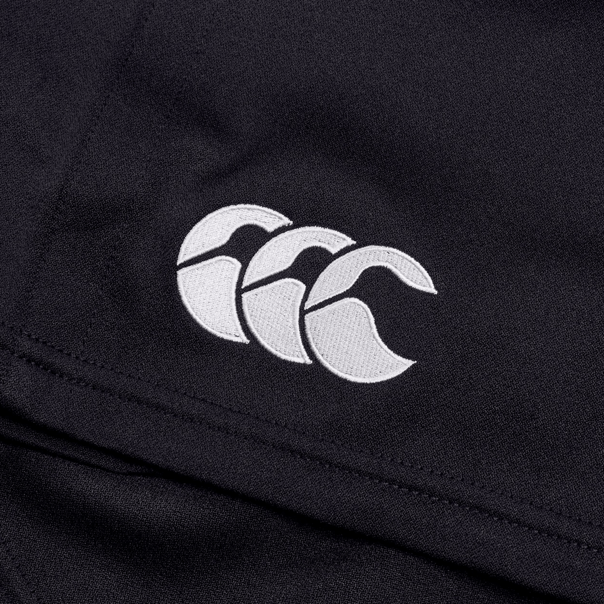 Close-up of black fabric featuring a white embroidered Canterbury logo with three overlapping C's, emphasizing the durability of the Canterbury Professional Short 2.0.