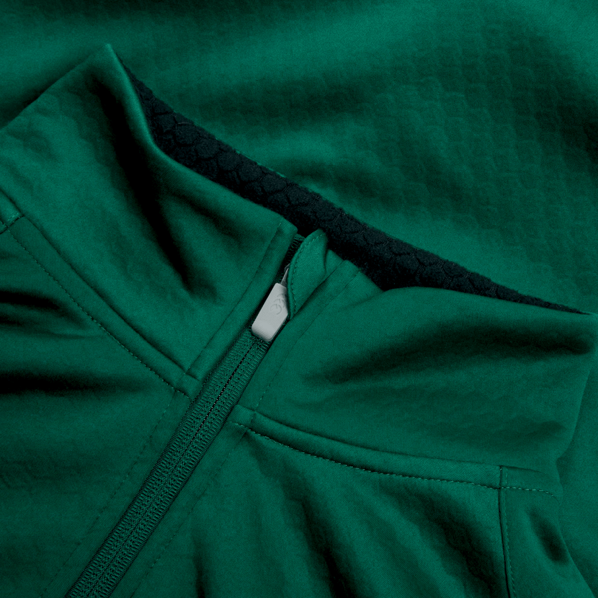 Close-up of the Ireland 1/4 Zip Training Top 25/26 by Canterbury, showing green textured fabric, visible inner lining, partially unzipped zipper, and Thermoreg technology for enhanced comfort.