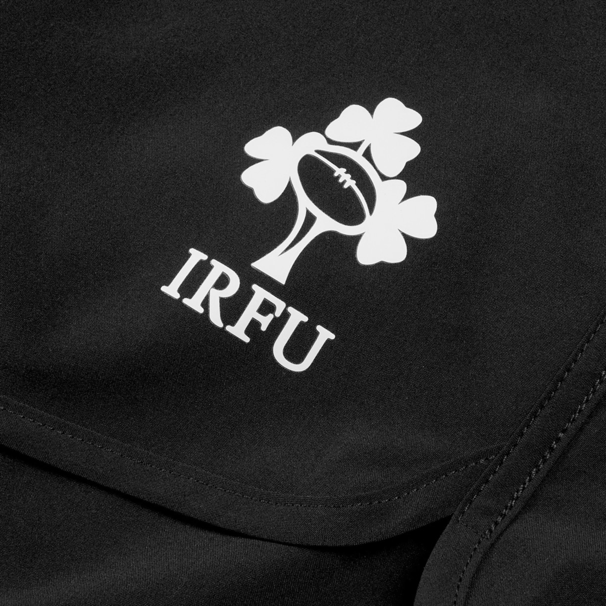 Close-up of Canterbury Women&#39;s Ireland 25/26 Woven Gym Shorts in black, showing the IRFU logo with a rugby ball and three shamrocks above &quot;IRFU.