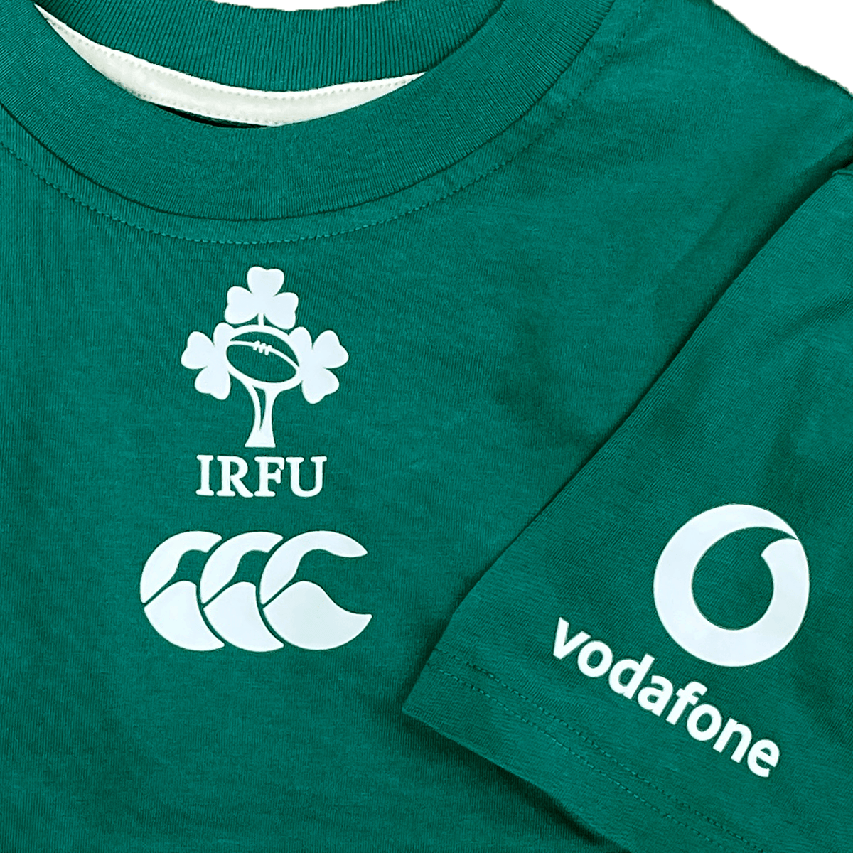 The Youth Ireland 24 Team Cotton T-Shirt by Canterbury features the IRFU logo with clovers, the Canterbury emblem, and Vodafone sponsor on the sleeve. Made from organic cotton, it combines comfort and style for young fans.