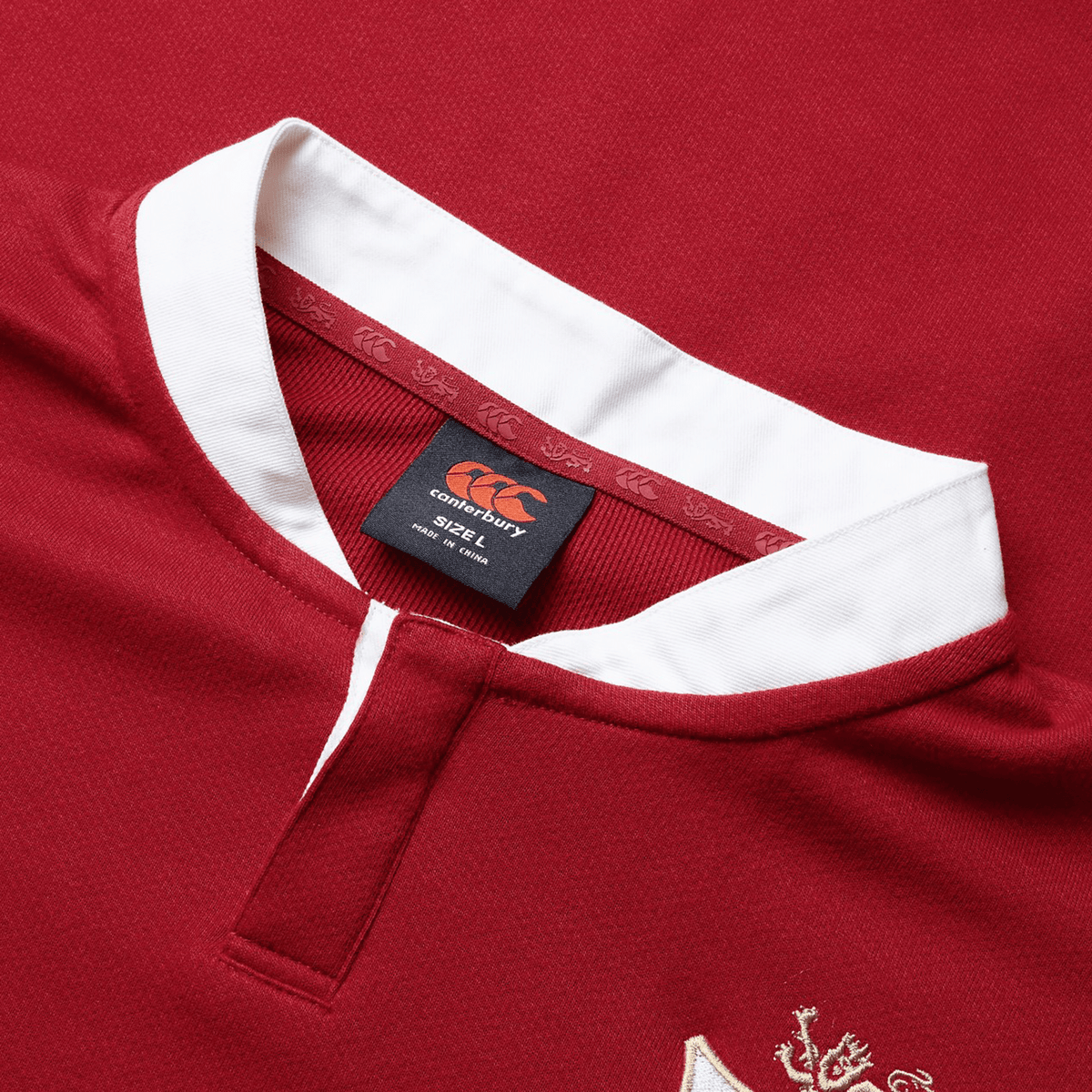 Close-up of the British &amp; Irish Lions 2025 Long Sleeve Classic Jersey by Canterbury, showcasing a vibrant red color with a white collar. The jersey features the Canterbury logo and a lion emblem, and is crafted from moisture-wicking fabric to provide comfort and style both on and off the field.
