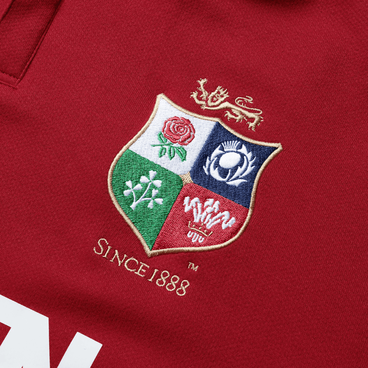 The British &amp; Irish Lions 2025 Long Sleeve Classic Jersey by Canterbury is a red sports shirt adorned with an embroidered crest showcasing a rose, thistle, shamrock, and dragon. Made from moisture-wicking fabric, the text beneath proudly declares "SINCE 1888.