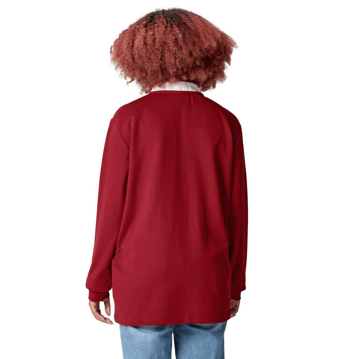 A person with curly hair wearing the red British &amp; Irish Lions 2025 Long Sleeve Classic Jersey by Canterbury, crafted from moisture-wicking fabric, along with jeans is shown from the back.