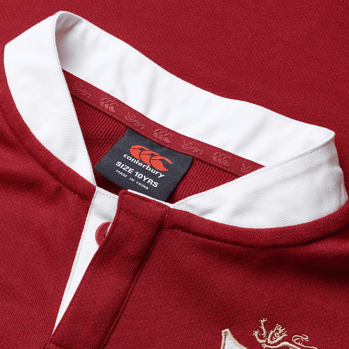 Close-up of the collar on the Youth British &amp; Irish Lions 2025 Long Sleeve Classic Jersey by Canterbury, featuring a red and white design with a moisture-wicking fabric, and showcasing the Canterbury logo label with size details.