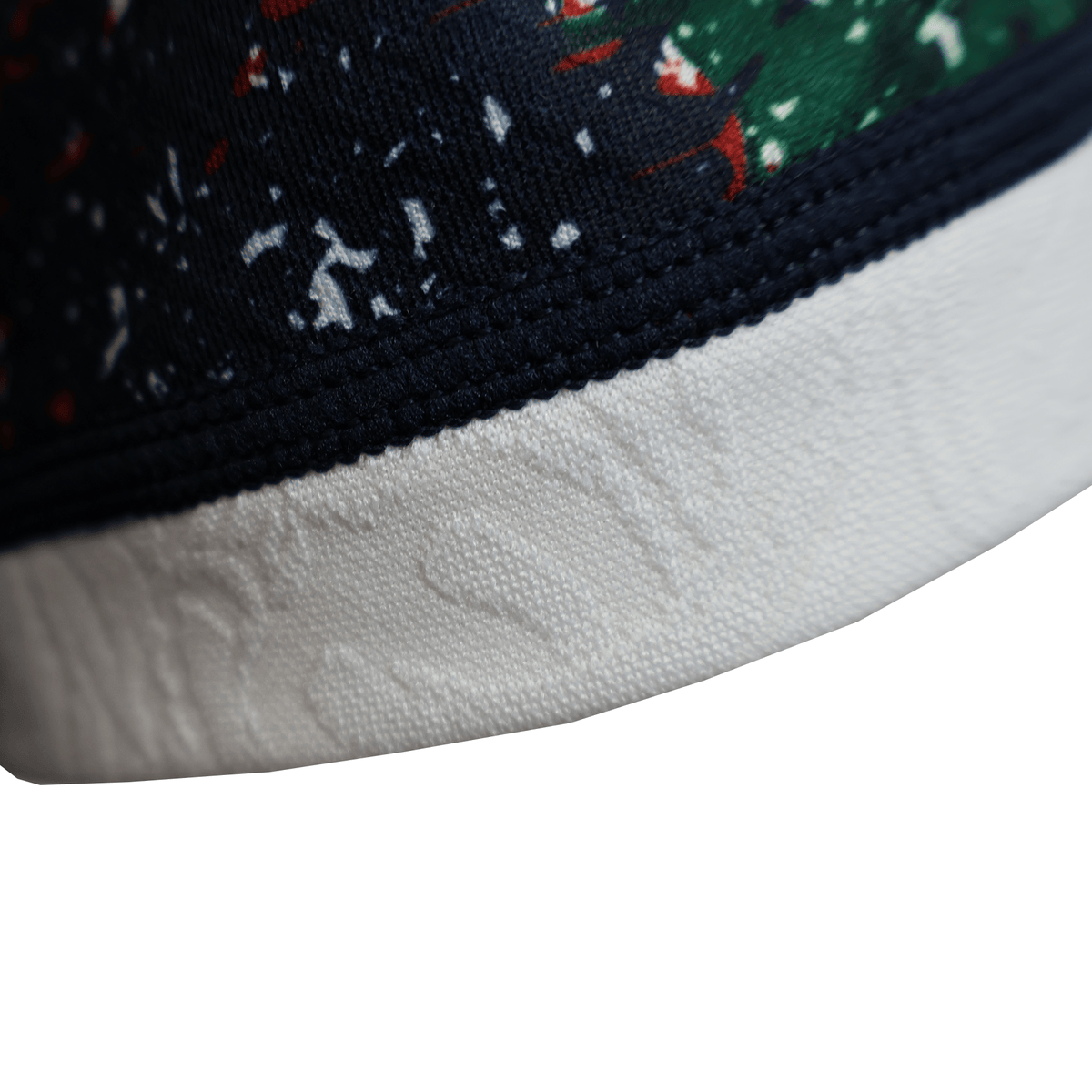 Close-up of the British &amp; Irish Lions 2025 Replica Warm Up Jersey by Canterbury featuring a navy and green pattern with small red details above a white textured band, exuding refined style.