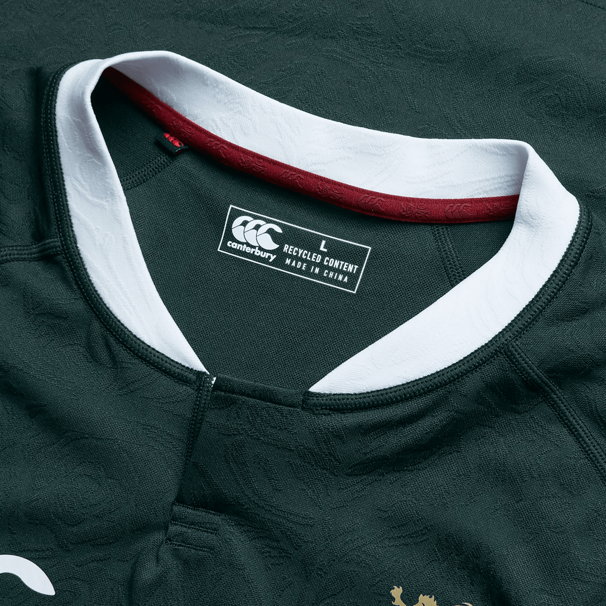 The British &amp; Irish Lions 2025 Training Jersey by Canterbury is a dark green replica jersey with white and maroon accents. It features a Canterbury label specifying size L and "Made in China from Recycled Polyester," making it an ideal choice for eco-conscious fans.