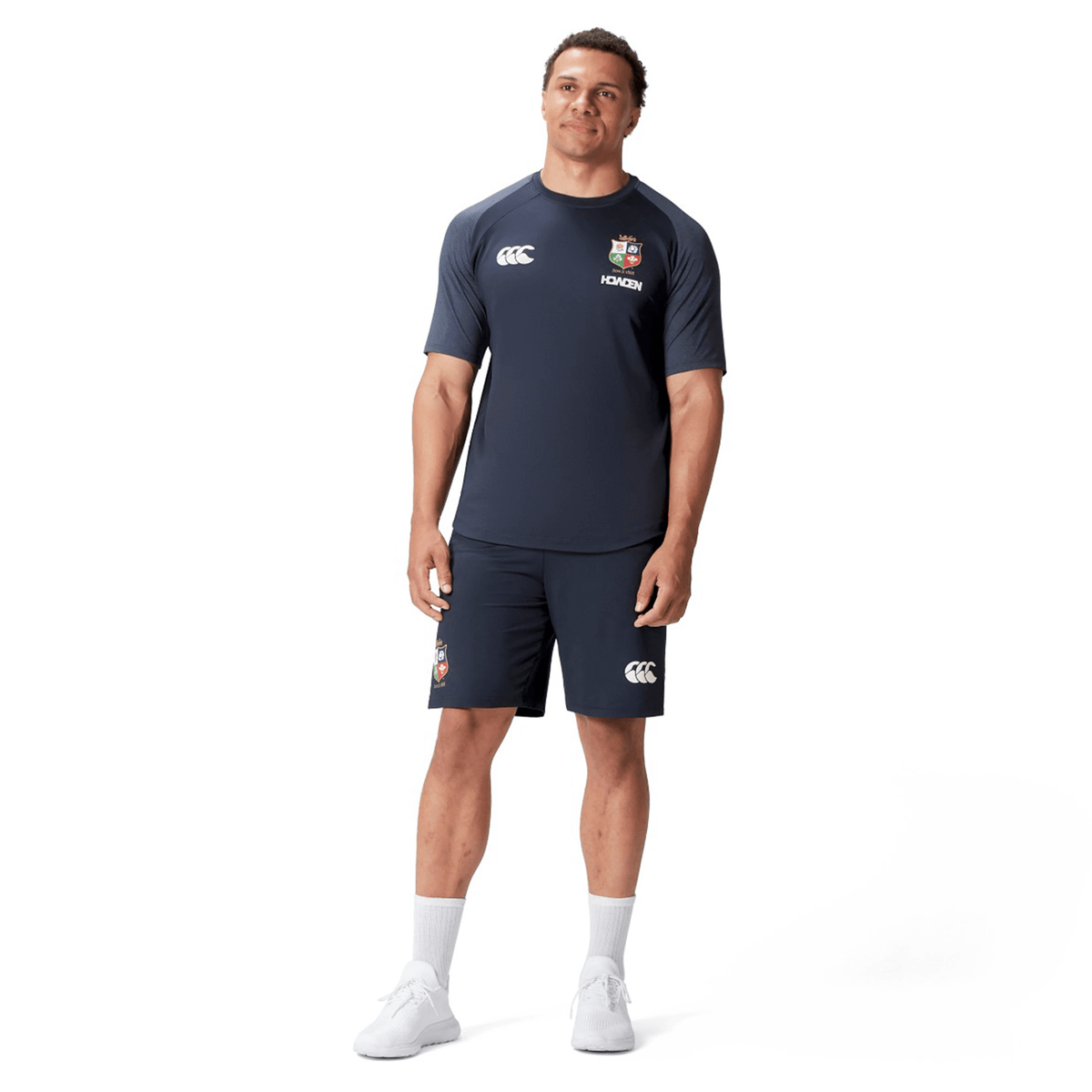 A man sporting the British &amp; Irish Lions 25 Everest Tee by Canterbury stands against a plain white background, embodying the spirit of the British &amp; Irish Lions.