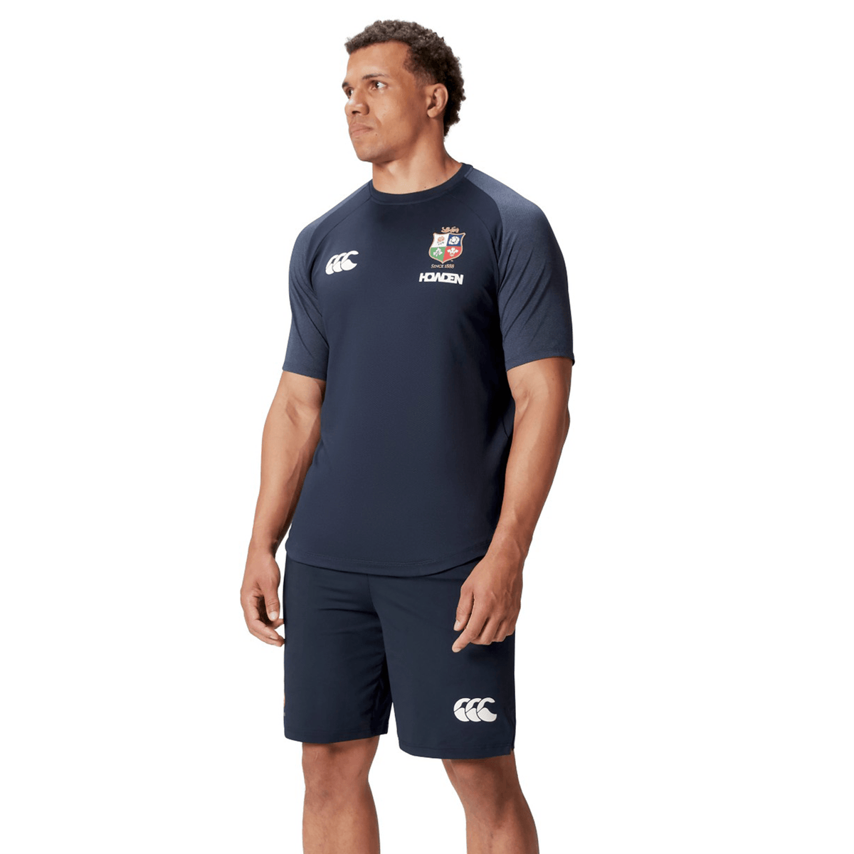 A man wearing the British &amp; Irish Lions 25 Everest Tee by Canterbury, elegantly showcases the brand’s signature style against a simple white background.