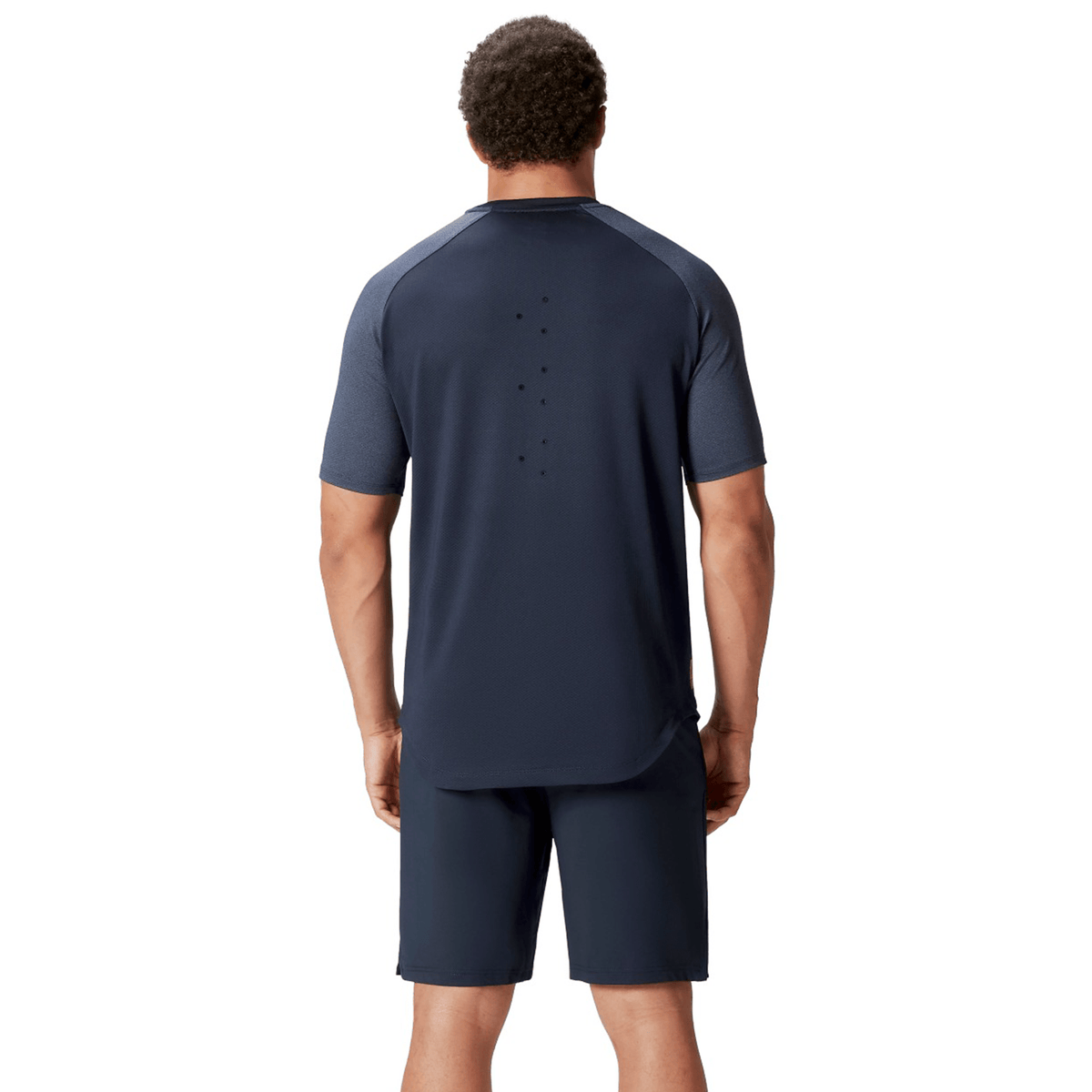 A person wearing a British &amp; Irish Lions 25 Everest Tee by Canterbury and shorts from Canterbury is standing with their back turned.