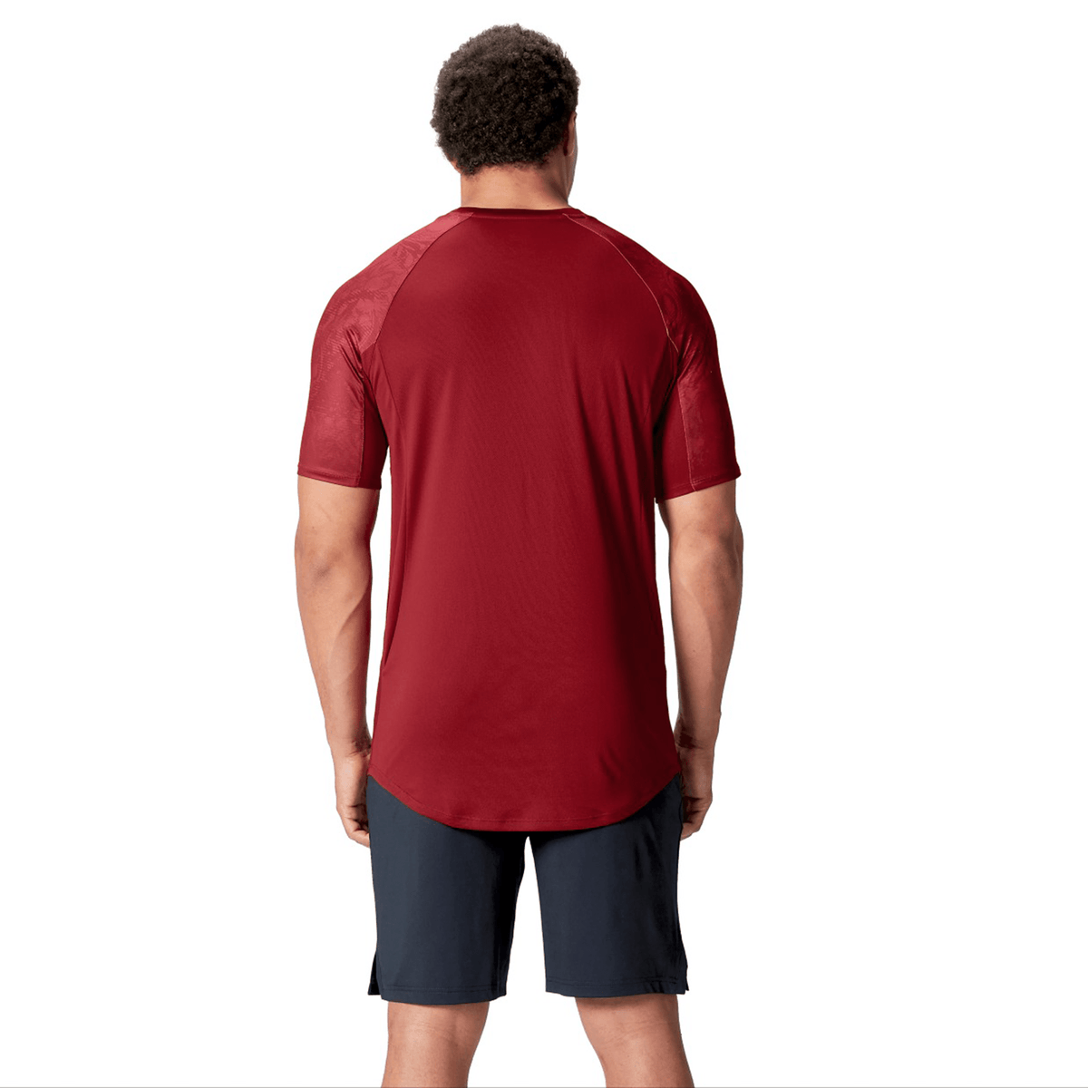 A person wearing a Canterbury British &amp; Irish Lions 25 Superlight Training Tee and dark shorts stands facing away against a plain white background.