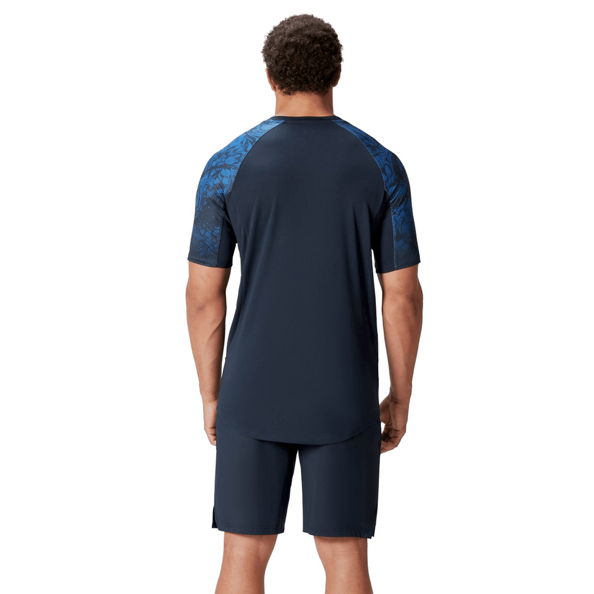 The individual is seen from the back wearing a navy British &amp; Irish Lions 25 Superlight Training Tee by Canterbury, featuring short sleeves and patterned shoulders.