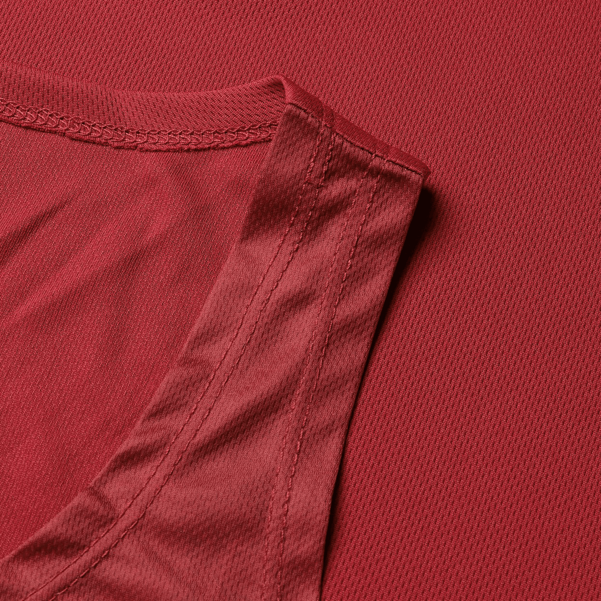 Close-up of a British &amp; Irish Lions 25 Poly Singlet by Canterbury, featuring a striking red hue and crafted from shiny, textured fabric, resting on a matching red textile surface.