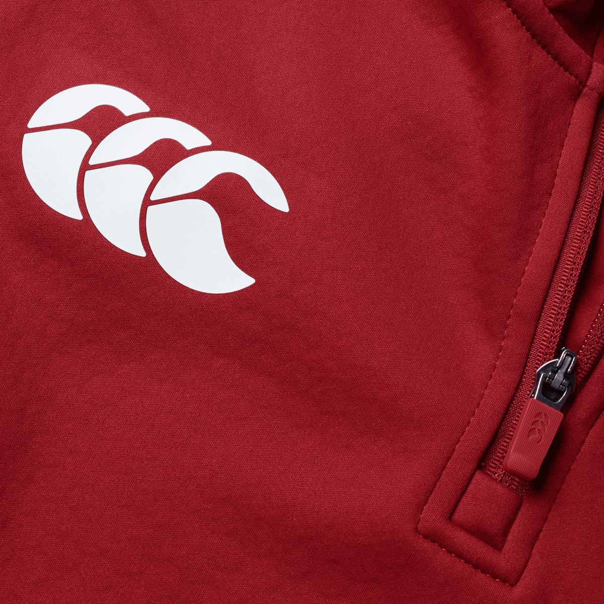 Close-up of the British &amp; Irish Lions 2025 1/4 Zip Fleece by Canterbury in red, featuring a white triple crescent logo and a zippered pocket on the right side.