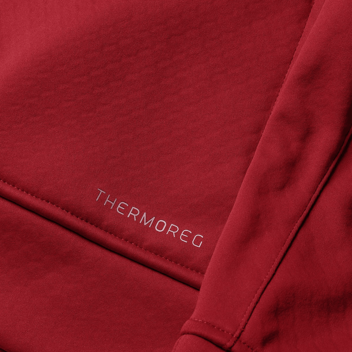 Close-up of red fabric from the British &amp; Irish Lions 2025 1/4 Zip Fleece by Canterbury, featuring &quot;THERMOREG&quot; printed in small white letters, evocative of high-performance gear preferred by the British &amp; Irish Lions.