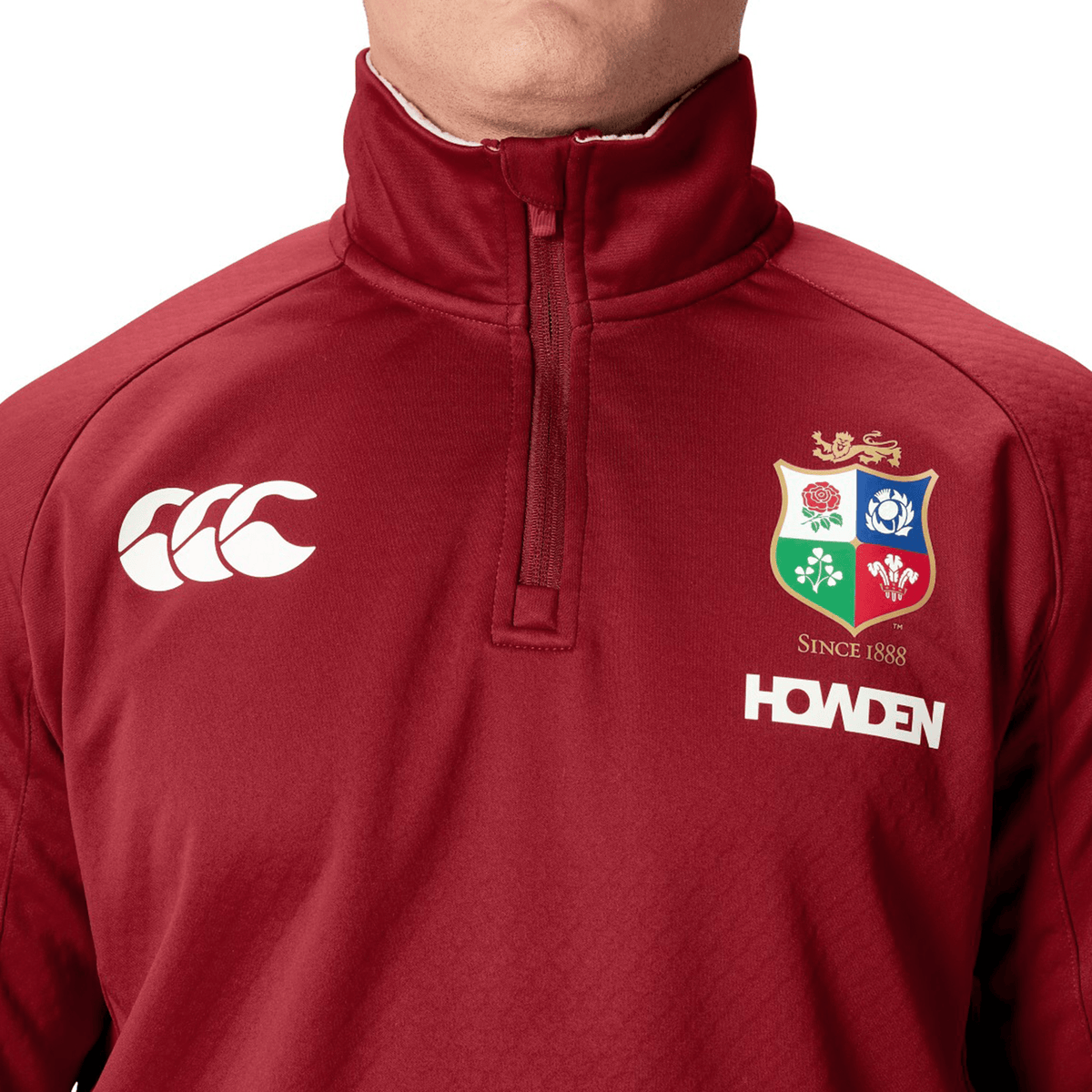 Close-up of a person wearing a maroon British &amp; Irish Lions 2025 1/4 Zip Fleece featuring the iconic crest and &quot;Howden&quot; logo, designed by Canterbury.