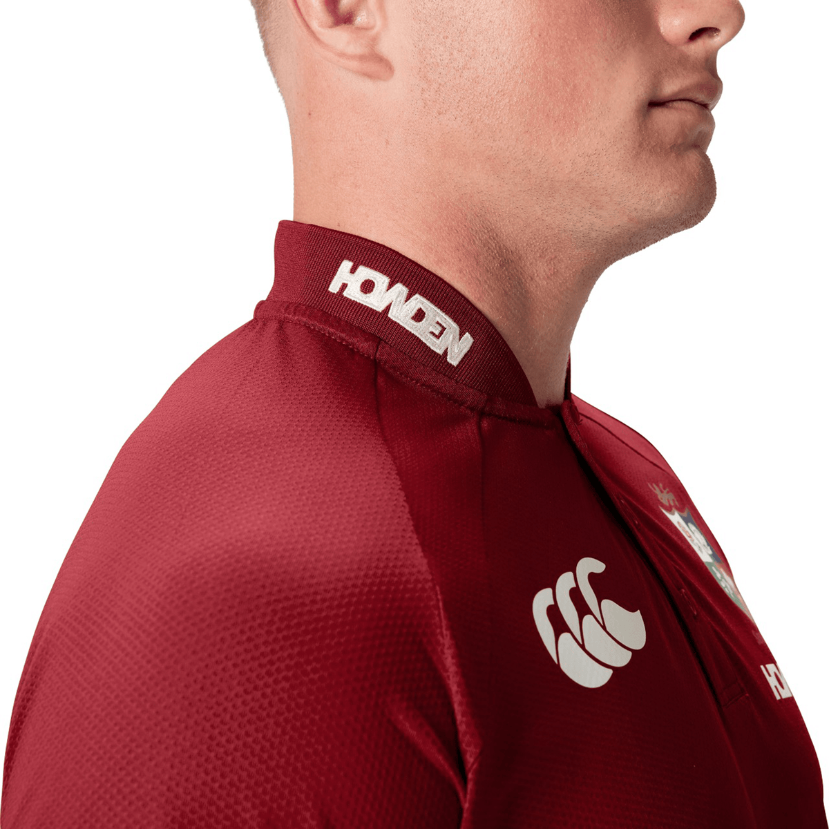 A man wearing the British &amp; Irish Lions 25 Poly Polo by Canterbury, featuring logo details and made from breathable fabric, seen from the side.