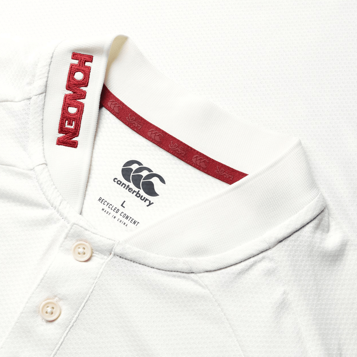 Here's a detailed look at the British &amp; Irish Lions 25 Poly Polo by Canterbury, showcasing a white fabric adorned with a red "HONDA" logo on the collar. Ideal for fans of the British &amp; Irish Lions, this polo shirt features three buttons and interior neck labels.
