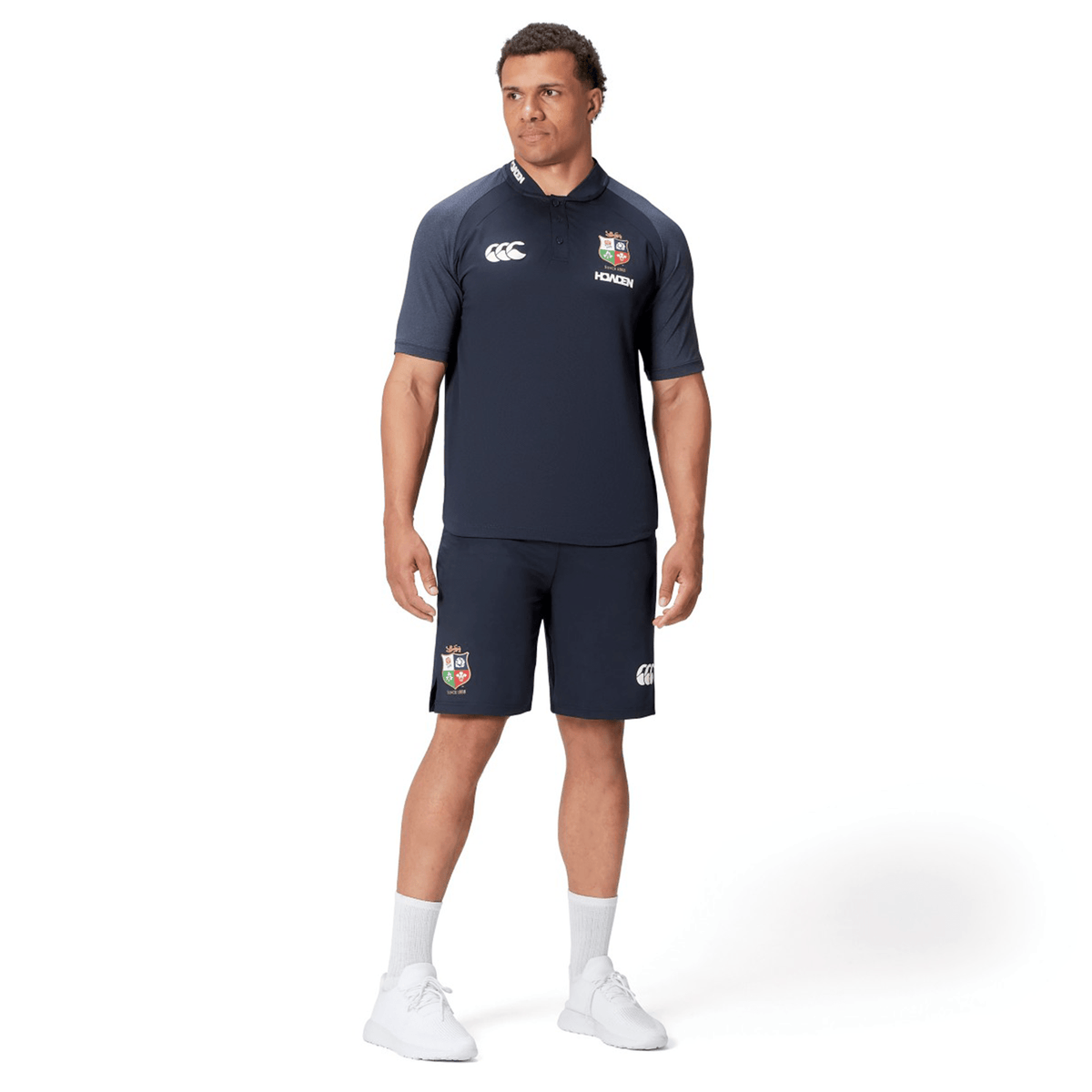 A man in a British &amp; Irish Lions 25 Poly Polo by Canterbury, made from quick-drying fabric, is standing against a white background.