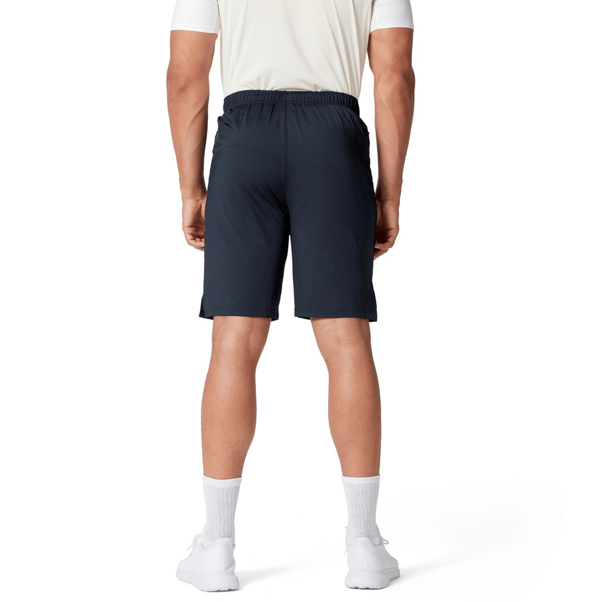 A person dressed in a white shirt, British &amp; Irish Lions 2025 Training Short by Canterbury, white socks, and white shoes stands with their back to the camera.