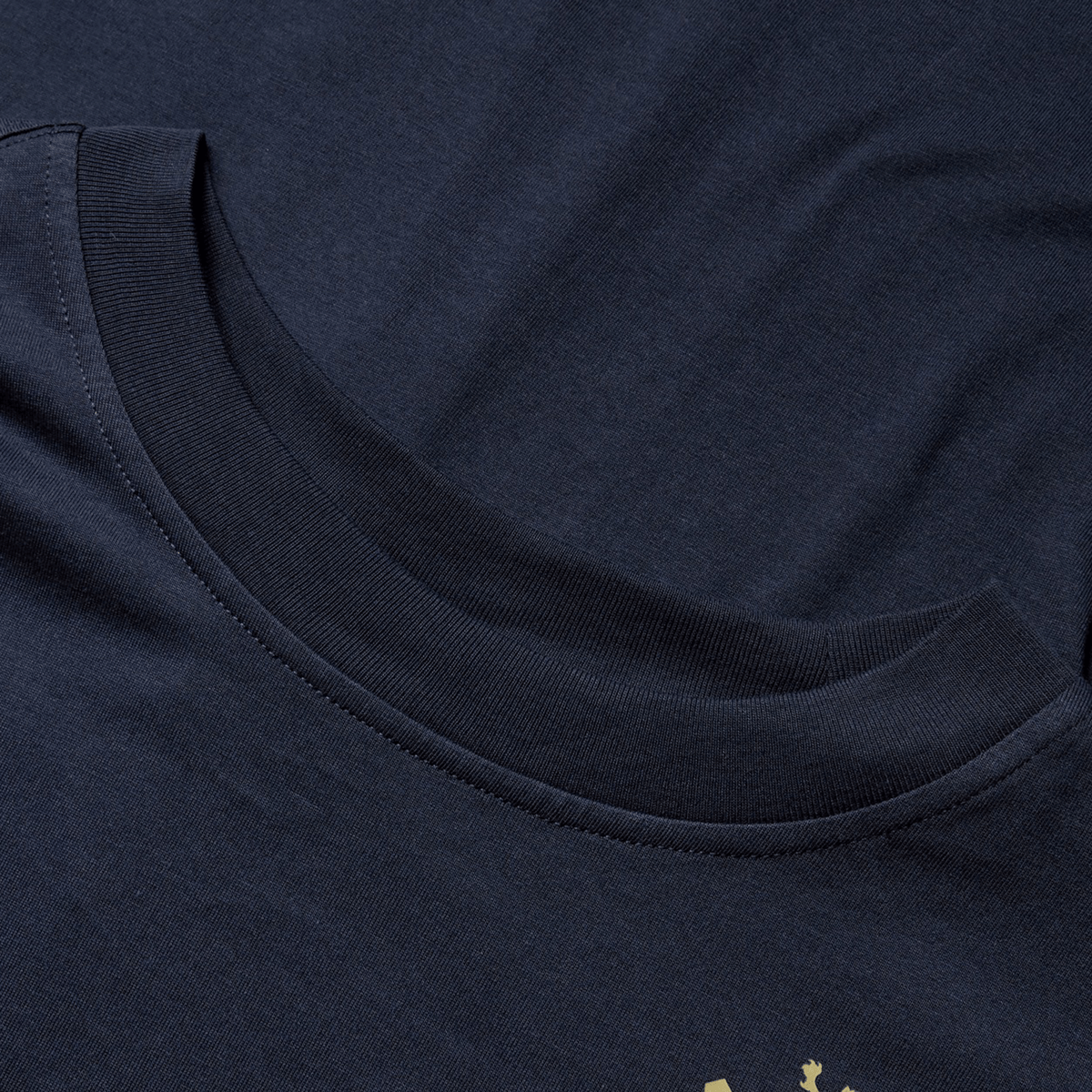 Close-up of the British &amp; Irish Lions 2025 Cotton Jersey Tee by Canterbury, showcasing its dark blue organic cotton fabric with a round neckline that highlights the texture and stitching details.