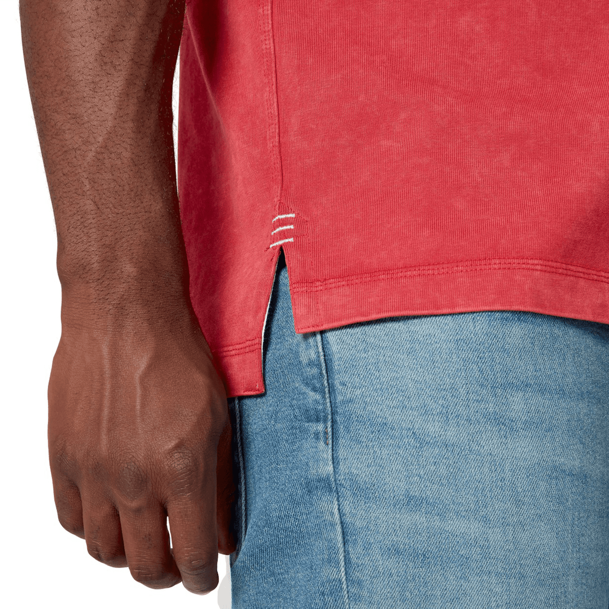 A person wearing a red British &amp; Irish Lions 25 Heritage Tee by Canterbury and light blue jeans, with their hand by their side, perfectly captures the classic style of Canterbury&#39;s British &amp; Irish Lions collection.